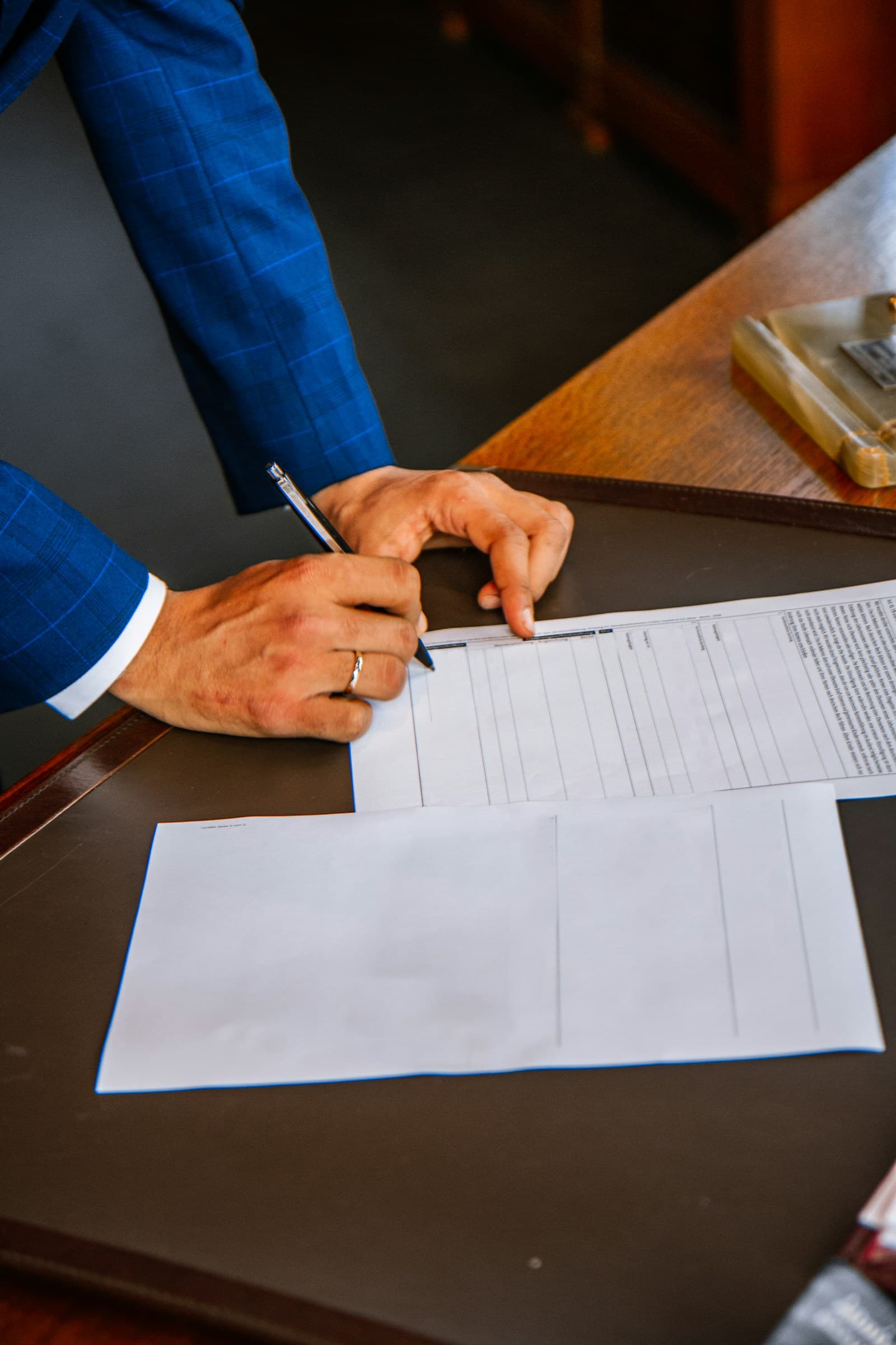 Mão assinando um contrato com caneta.